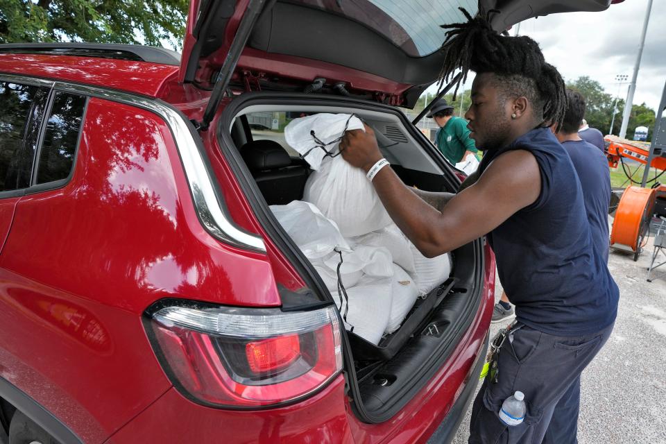 Members of the Tampa Parks and Recreation Department help residents with sandbags on Aug. 28, 2023, in Tampa, Fla