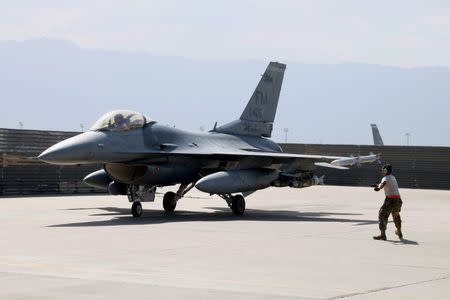 A U.S. Air Force crew chief signals the pilot of an F-16 Flying Falcon as it taxis for a mission at Bagram air field in Afghanistan August 11, 2016. REUTERS/Josh Smith