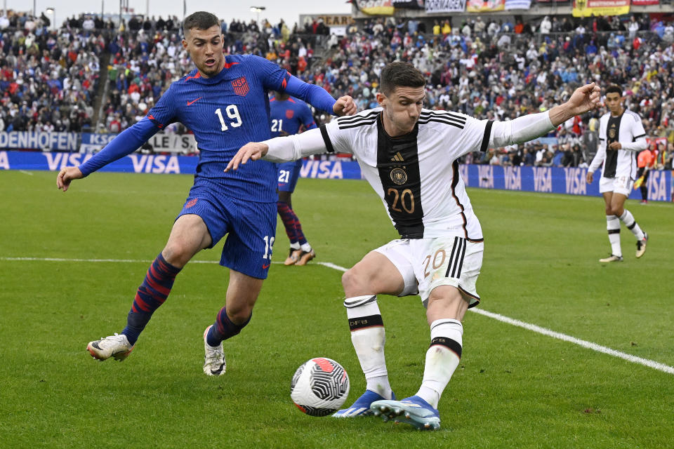 Germany's Robin Gosens, right, plays the ball as United States' Joe Scally defends during an international friendly soccer match at Pratt & Whitney Stadium at Rentschler Field, Saturday, Oct. 14, 2023, in East Hartford, Conn. (AP Photo/Jessica Hill)