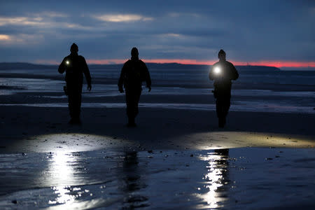French gendarmes patrol the beach just after sunset in Wissant, France, January 11, 2019. Picture taken January 11, 2019. REUTERS/Pascal Rossignol