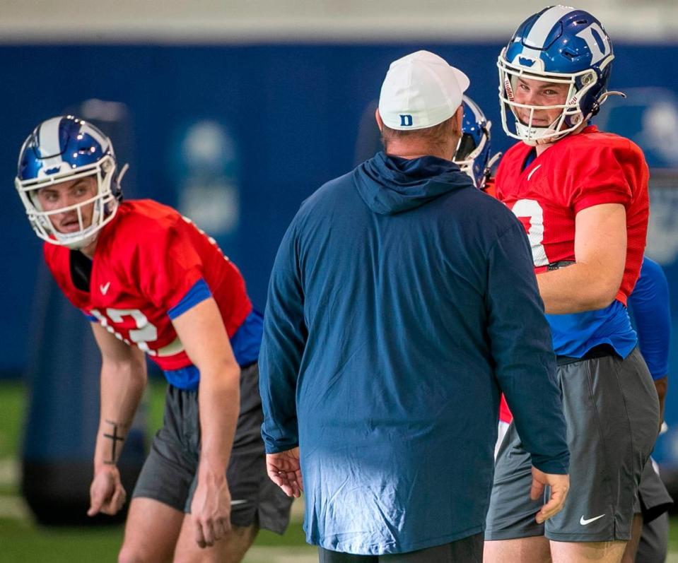 Duke quarterbacks Grayson Loftis (12), left, and Riley Leonard (13) listen to head coach Mike Elko during the Blue Devils’ spring practice on Friday, March 24, 2023 in Durham, N.C.