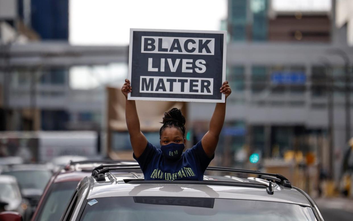 A person holds a placard out of a car's sunroof after the guilty verdict in the trial of former Minneapolis police officer Derek Chauvin, which relied heavily on video footage - CARLOS BARRIA /REUTERS 