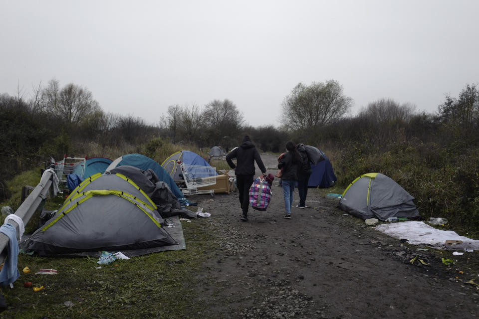 A migrants makeshift camp is set up along the river in Loon Plage, near Grande-Synthe, northern France, Friday, Nov. 26, 2021. Children and pregnant women were among at least 27 migrants who died when their small boat sank in an attempted crossing of the English Channel, a French government official said Thursday. (AP Photo/Rafael Yaghobzadeh)