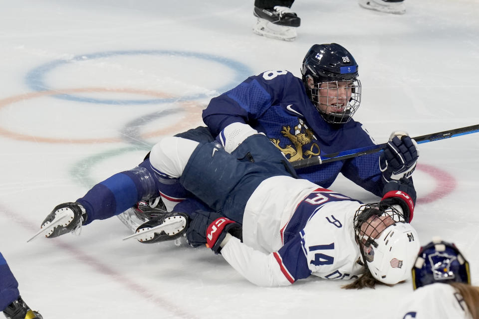 United States' Brianna Decker (14) lies on the ice after colliding with Finland's Ronja Savolainen (88) during a preliminary round women's hockey game at the 2022 Winter Olympics, Thursday, Feb. 3, 2022, in Beijing. (AP Photo/Petr David Josek)