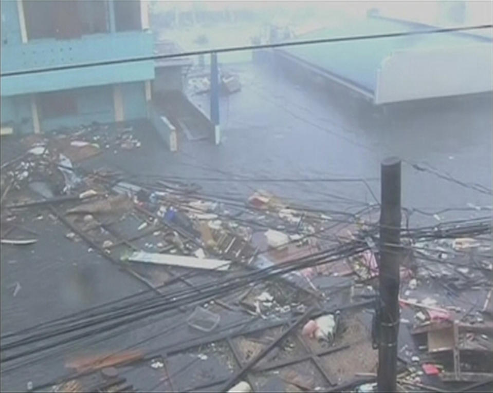 Debris float on a flooded road as strong winds and rain continue to batter buildings after Typhoon Haiyan hit Tacloban city, Leyte province