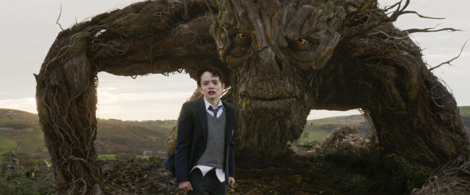This image released by Focus Features, Lewis MacDougall appears with The Monster, voiced and performed by Liam Neeson, in a scene from "A Monster Calls." (Focus Features via AP)