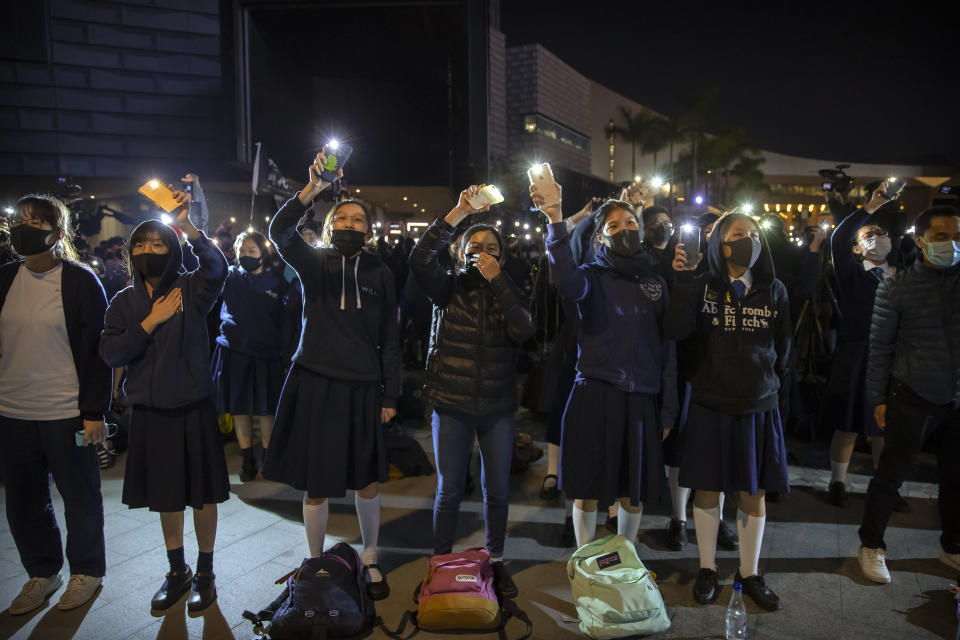 Protesters wave their smartphones as they sing "Glory to Hong Kong" during a rally for secondary school students near the Hong Kong Museum of Art in Hong Kong, Friday, Dec. 13, 2019. Protesters in Hong Kong wrote hundreds of Christmas cards on Thursday for people jailed in the city's pro-democracy movement, promising they won't be forgotten as they face spending the festive season behind bars. (AP Photo/Mark Schiefelbein)