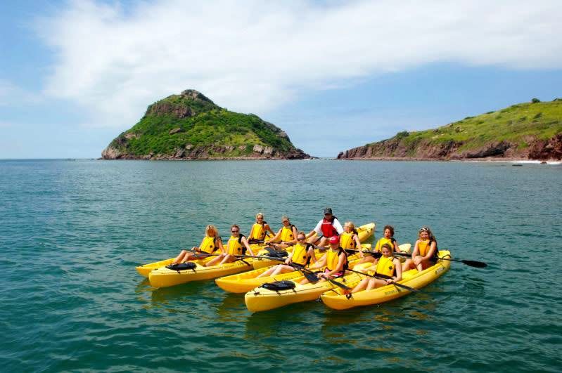 a group of people in yellow canoes in the water