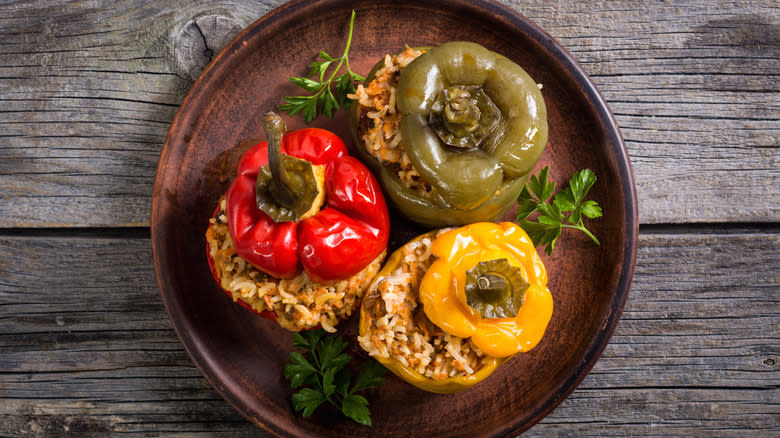 three stuffed peppers with tops