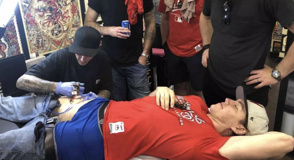 T.J. Oshie lays on a bench while getting inked. (Photo from www.russianmachineneverbreaks.com)