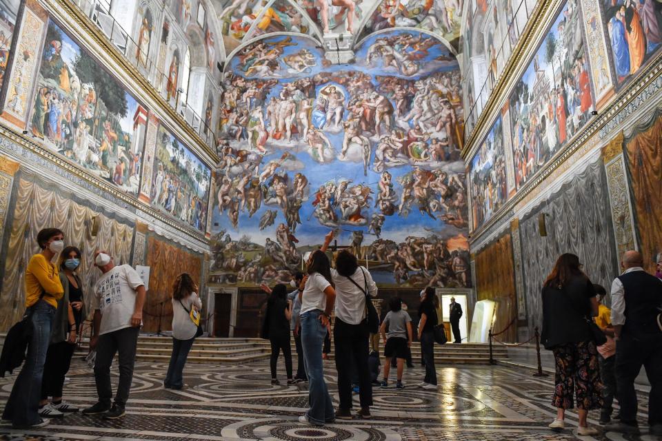 Tourists with protective masks in the Sistine Chapel