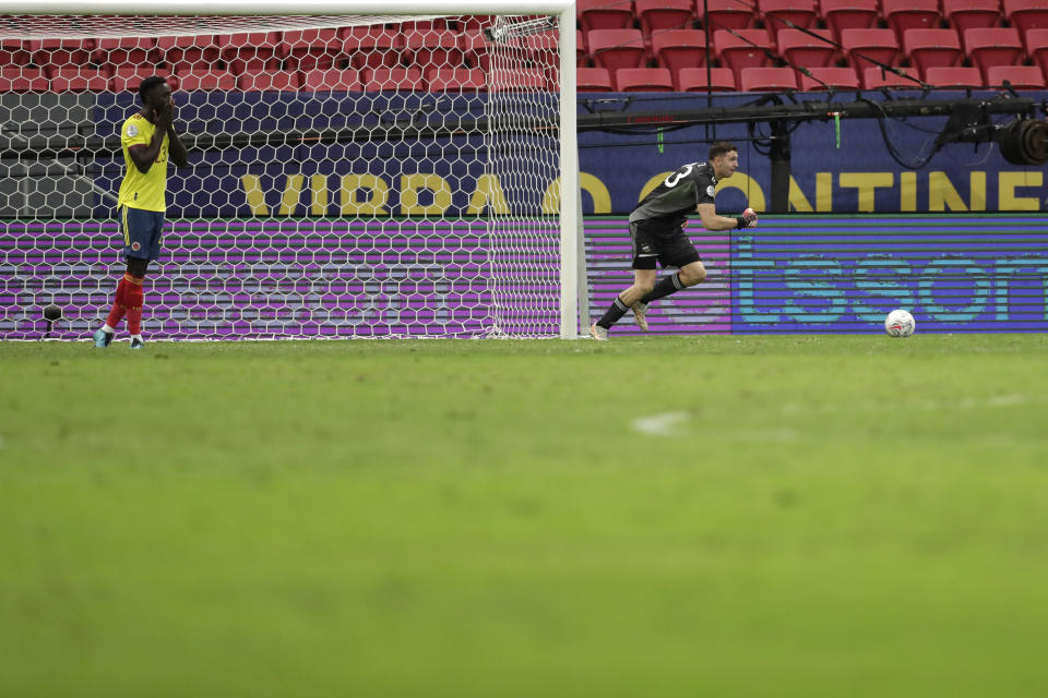 Argentina's goalkeeper Emiliano Martinez, right, reacts after stoping a penalty shot by Colombia's Davinson Sanchez, left, in a the penalty shootout during a Copa America semifinal soccer match at the National stadium in Brasilia, Brazil, Wednesday, July 7, 2021. (AP Photo/Eraldo Peres)