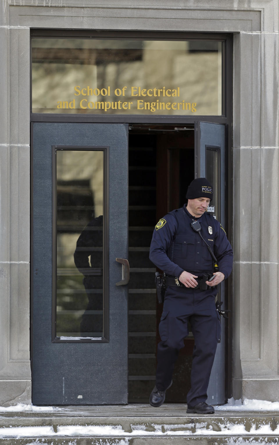 A police officer walks out of the Electrical Engineering Building on the campus of Purdue University in West Lafayette, Ind., Tuesday, Jan. 21, 2014 where one person was killed inside a classroom by a gunman who surrendered to a police officer within minutes of the attack, officials said.. (AP Photo/Michael Conroy)
