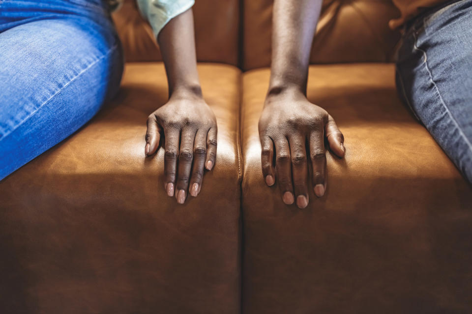 two hands on either side of the couch with people sitting next to each other