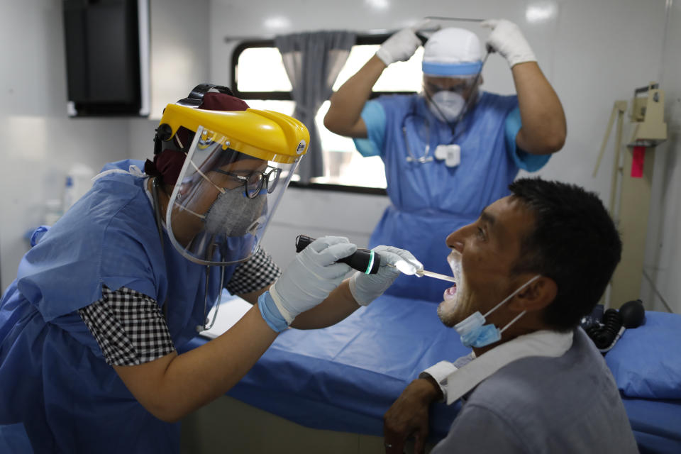 La doctora Anahí Moreno examina a José Ramón Reséndiz Martínez, un diabético de 43 años que lleva seis meses viviendo en la calle desde que se le acabó el dinero para la renta, en una clínica móvil del gobierno, en la Ciudad de México, el miércoles 8 de abril de 2020. (AP Foto/Rebecca Blackwell)