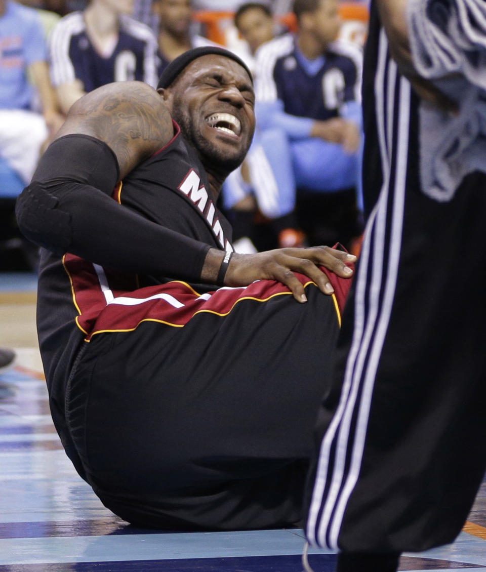 Miami Heat's LeBron James grimaces after being injured during the second half in Game 4 of an opening-round NBA basketball playoff series against the Charlotte Bobcats in Charlotte, N.C., Monday, April 28, 2014. (AP Photo/Chuck Burton)