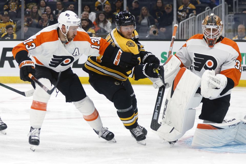 Philadelphia Flyers' Kevin Hayes (13) defends against Boston Bruins' Chris Wagner (14) during the first period of a preseason NHL hockey game, Saturday, Oct. 1, 2022, in Boston. (AP Photo/Michael Dwyer)