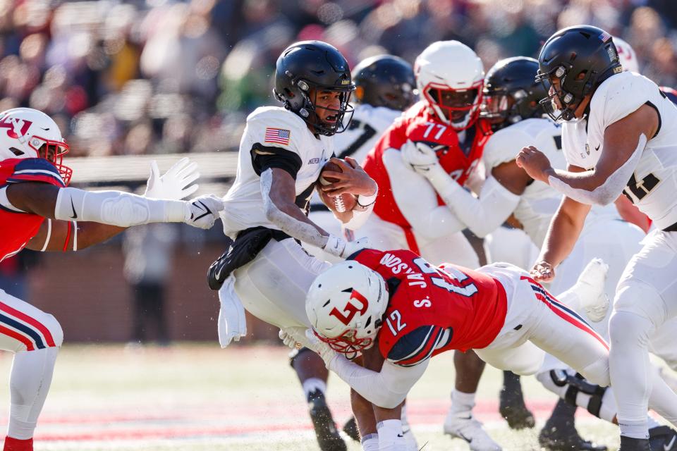 Army quarterback Christian Anderson (4) is tackled by Liberty's Stoney Jackson on Saturday. Army won 31-16. CHASE GYLES/For Liberty Athletics