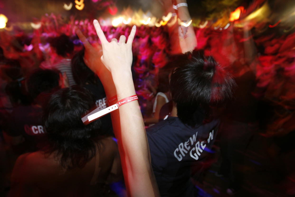 Revellers dance during the annual ZoukOut dance party in Singapore December 9, 2007. ZoukOut, a spinoff from popular Singaporean nightclub Zouk, takes place from dusk till dawn along Siloso Beach on Sentosa Island, and is attended by tens of thousands of clubbers from Singapore and all over the region.  REUTERS/Vivek Prakash (SINGAPORE)