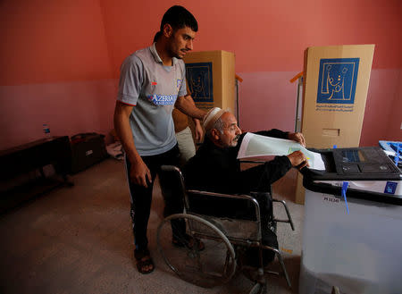 An Iraqi man in a wheelchair casts his vote at a polling station during the parliamentary election in Mosul, Iraq May 12, 2018. REUTERS/Khalid al-Mousily