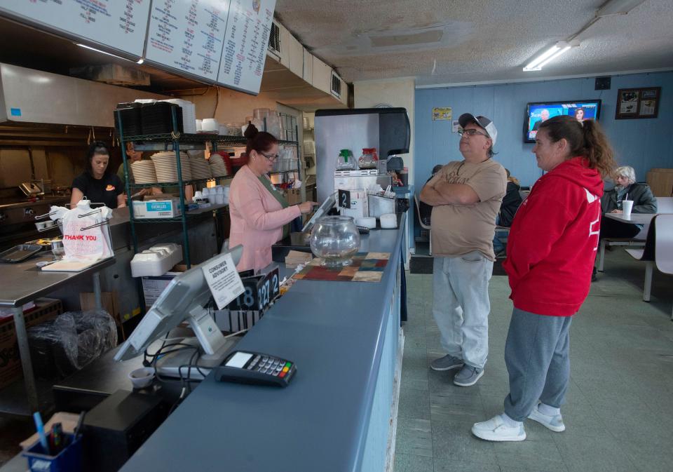 First-time customers Misty and Harry Phillips scan the menu at Grover's Fingers and Wings on Friday. After years of driving past Grover's and hearing friends sing its praises, they decided to give it a try for themselves.