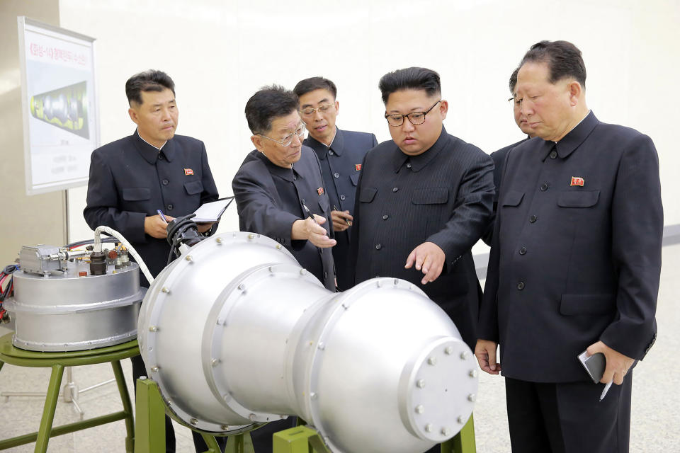 This undated picture released by North Korea’s official Korean Central News Agency in September shows Kim Jong Un, center, at an undisclosed location looking at a metal casing with two bulges. (Photo: STR/AFP/Getty Images)