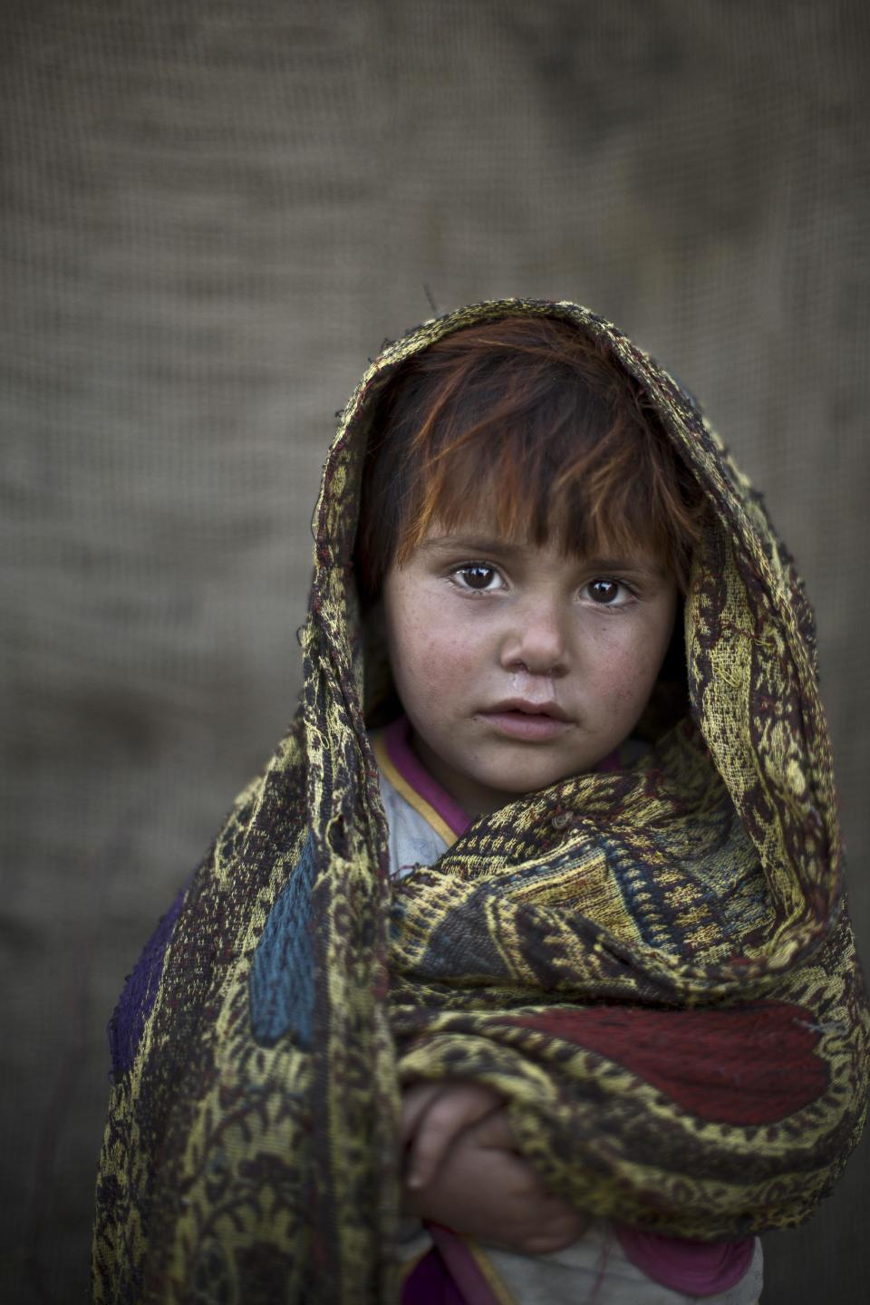 In this Friday, Jan. 24, 2014 photo, Afghan refugee girl, Safia Mourad, 4, poses for a picture, while playing with other children in a slum on the outskirts of Islamabad, Pakistan. For more than three decades, Pakistan has been home to one of the world’s largest refugee communities: hundreds of thousands of Afghans who have fled the repeated wars and fighting their country has undergone. Since the 2002 U.S.-led invasion of Afghanistan, some 3.8 million Afghans have returned to their home country, according to the U.N.’s refugee agency. (AP Photo/Muhammed Muheisen)