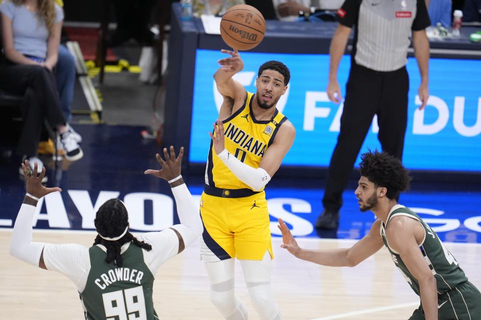 Indiana Pacers' Tyrese Haliburton (0) makes a pass against Milwaukee Bucks' Jae Crowder (99) and Andre Jackson Jr. during the second half of Game 4 of the first round NBA playoff basketball series, Sunday, April 28, 2024, in Indianapolis. (AP Photo/Michael Conroy)