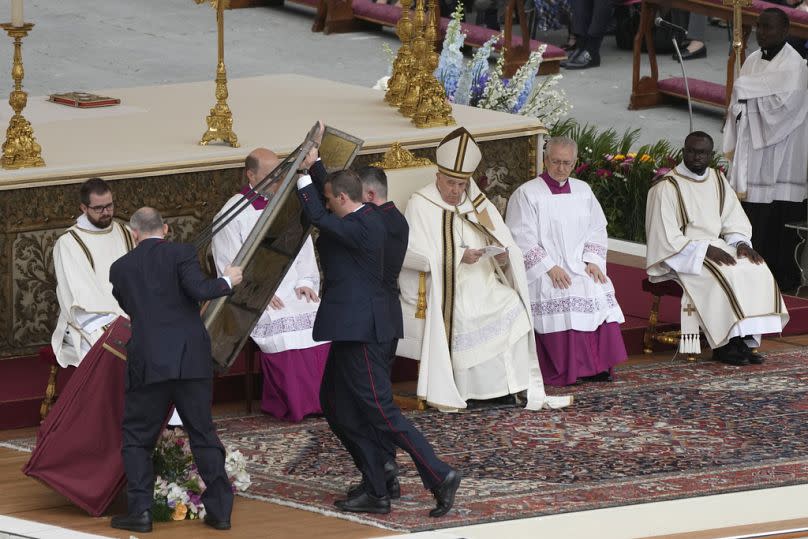 Vatican ushers raise the icon of the holy savior as Pope Francis celebrates Easter mass in St. Peter's Square at the Vatican, Sunday, March 31, 2024.