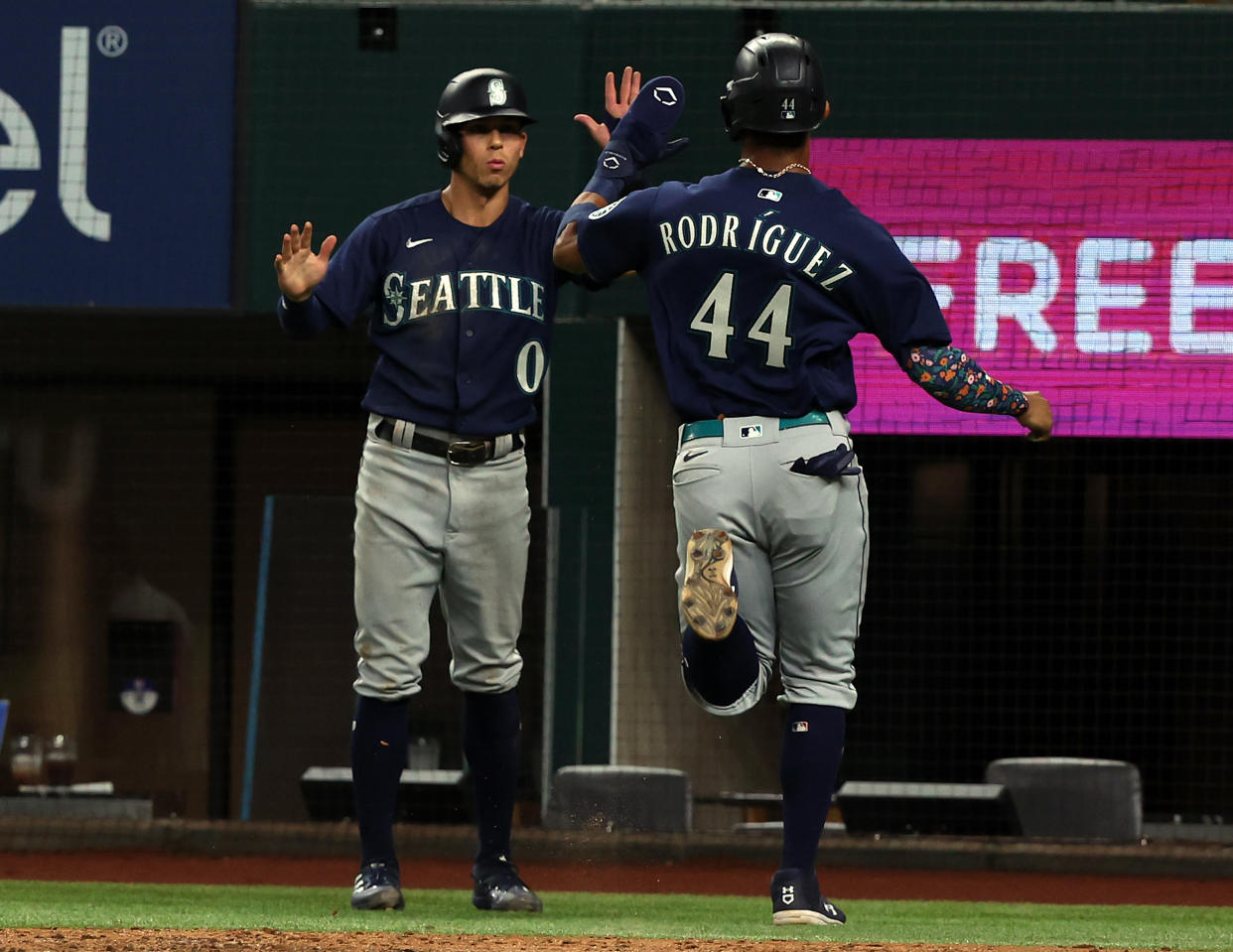 ARLINGTON, TEXAS - JULY 14: Julio Rodriguez #44 and Sam Haggerty #0 of the Seattle Mariners celebrate scoring on a single by Carlos Santana in the seventh inning against the Texas Rangers at Globe Life Field on July 14, 2022 in Arlington, Texas. (Photo by Richard Rodriguez/Getty Images)