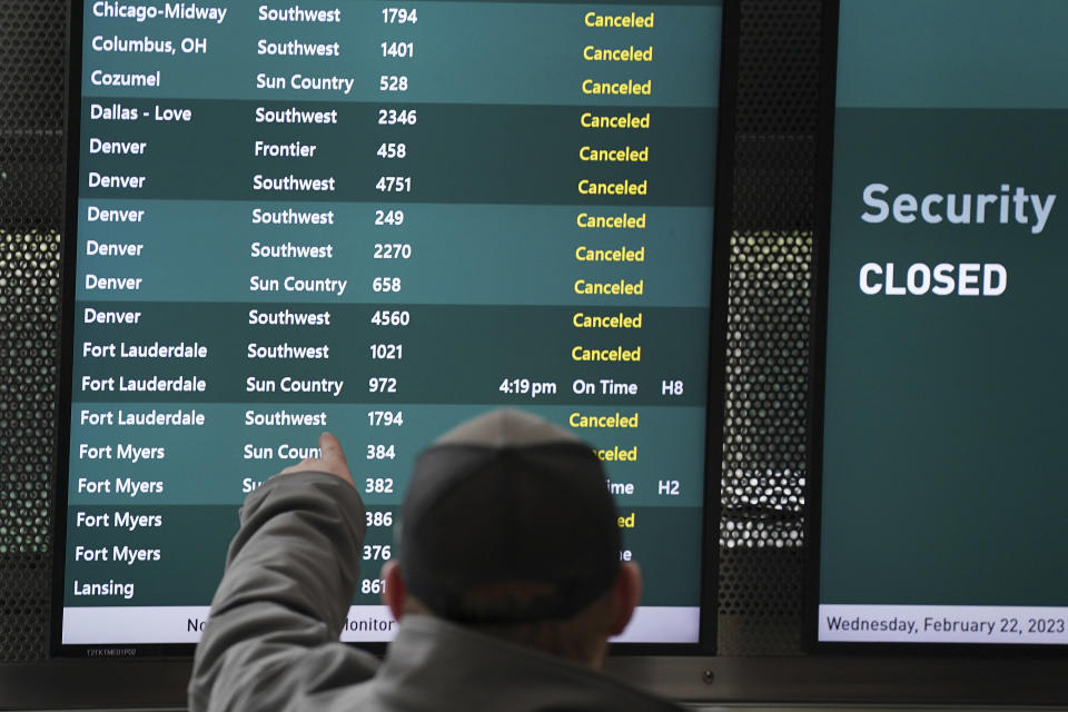 A passenger views information boards at Minneapolis-Saint Paul International Airport showing canceled flights ahead of an impending snow storm forecasted to hit the Twin Cities later in the day Wednesday, Feb. 22, 2023 in St. Paul, Minn. (Anthony Souffle/Star Tribune via AP)