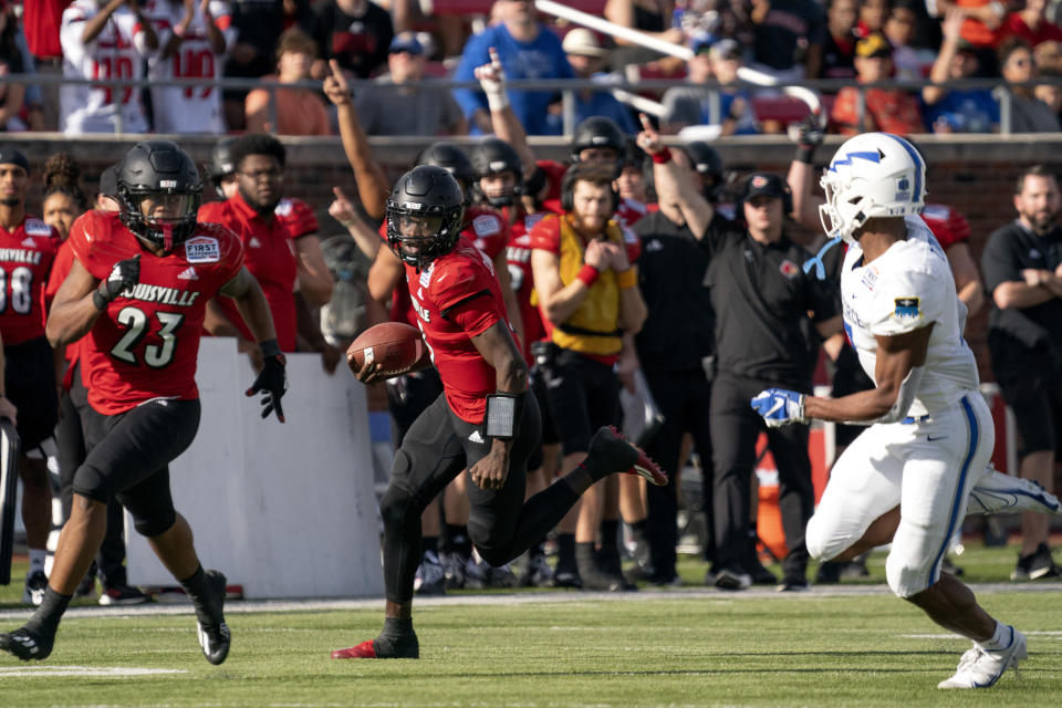 Louisville quarterback Malik Cunningham (3) runs upfield as running back Trevion Cooley (23) looks to set a block on Air Force safety Trey Taylor (7) during the first half of the First Responder Bowl NCAA college football game Tuesday, Dec. 28, 2021, in Dallas. (AP Photo/Jeffrey McWhorter)