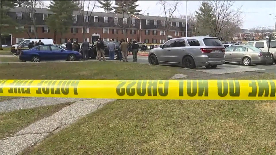 This image provided by WMAR-2 News shows emergency and law enforcement officials responding to the scene of a shooting, Wednesday, Feb. 12, 2020 in Baltimore. Two law enforcement officers with a fugitive task force were injured and a suspect died in a shooting on Wednesday, the U.S. Marshals Service said. (WMAR-2 News via AP)
