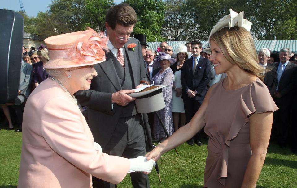 <p> Hundreds of onlookers watched as Queen Elizabeth welcomed journalist Katie Couric to her Buckingham Palace Garden Party, for which she was dressed in a mauve shift dress and white fascinator. </p>