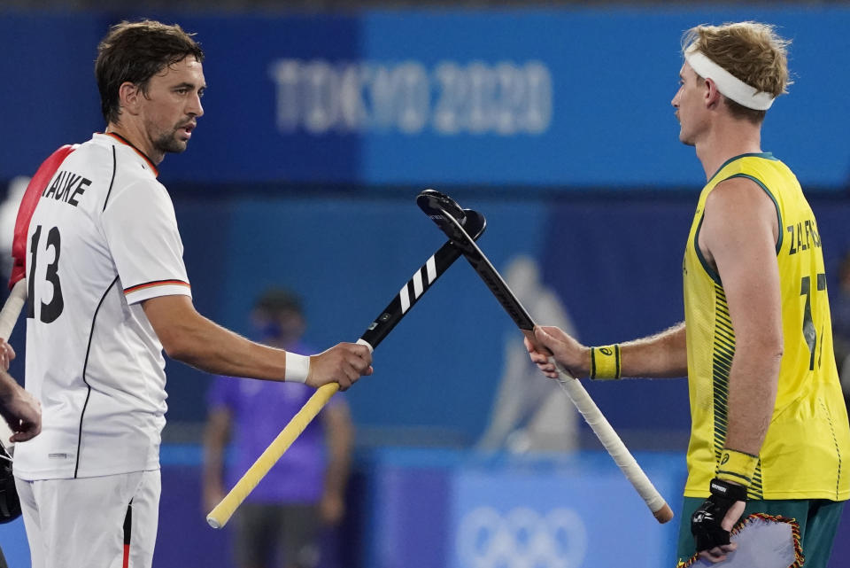 FILE - In this Aug. 3, 2021 file photo, Germany's Tobias Constantin Hauke, left, and Australia's Aran Zalewski (17) greet each other before a men's field hockey semi-final match at the 2020 Summer Olympics in Tokyo, Japan. As workers return to the office, friends reunite and more church services shift from Zoom to in person, this exact question is befuddling growing numbers of people: to shake or not to shake. (AP Photo/John Minchillo, File)