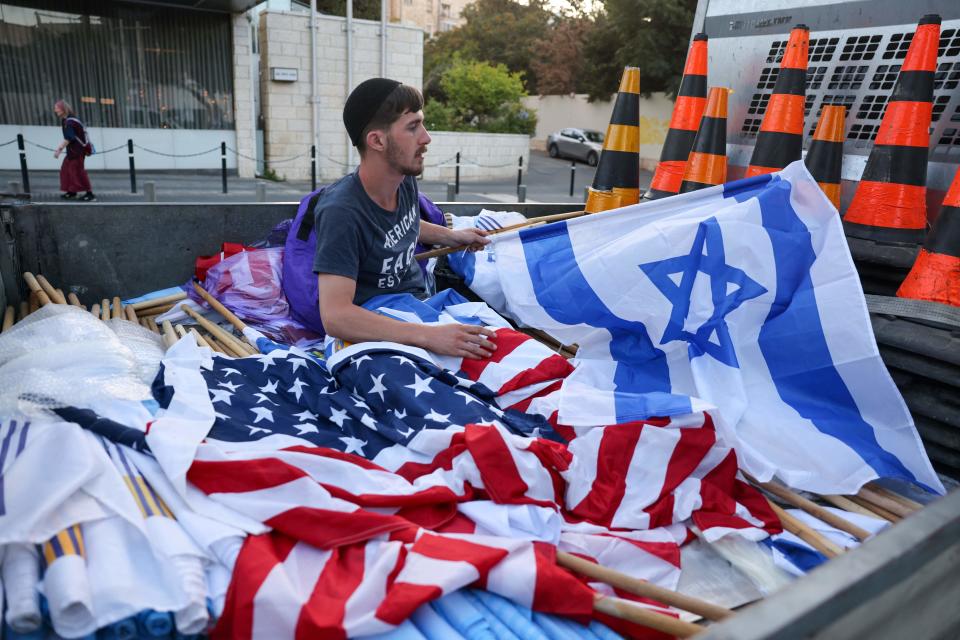 A worker prepares Israeli and US national flag on July 12, 2022, in Jerusalem, ahead of US President Joe Biden's visit to Israel tomorrow.