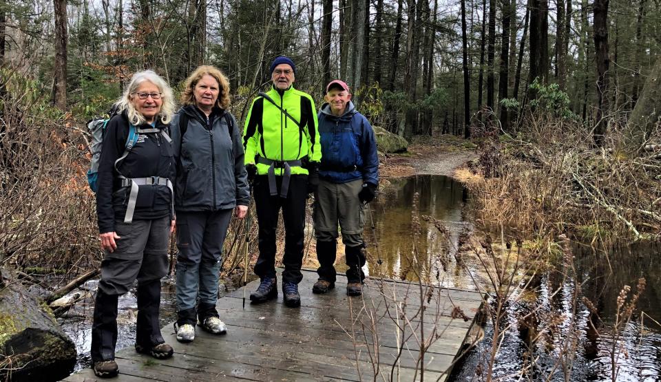 From left, Appalachian Mountain Club hike leader Éva Borsody Das, of Hull; Ann Rega, of Scituate; and Richard Carnes and Ed Fopiano, both of Middleboro, explore the flooded trails at Whitney Thayer Woods in Hingham and Cohasset after a rainy night. All are wearing gaiters. The hike was sponsored by the Southeastern Massachusetts Chapter of the Appalachian Mountain Club. Thursday, Jan. 26, 2023.