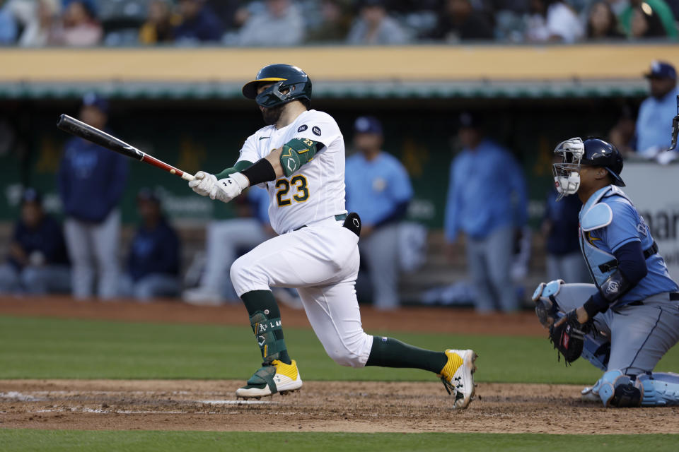 Oakland Athletics' Shea Langeliers (23) hits a three-run double in front of Tampa Bay Rays catcher Christian Bethancourt, right, during the fifth inning of a baseball game in Oakland, Calif., Monday, June 12, 2023. (AP Photo/Jed Jacobsohn)