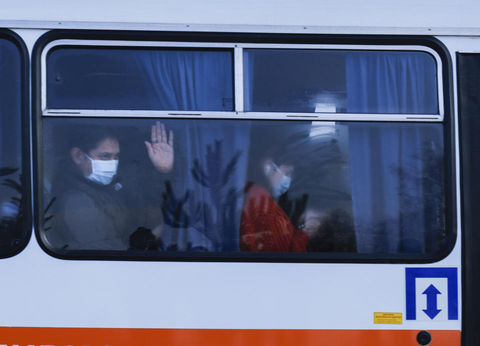 Busses with passengers from the Ukrainian aircraft chartered by the Ukrainian government for evacuation from the Chinese city of Wuhan, leave the the gate upon their landing at airport outside Kharkiv, Ukraine, Thursday, Feb. 20, 2020. Ukraine's effort to evacuate more than 70 people from China due to the outbreak of the new COVID-19 virus was delayed because of bad weather as evacuees travel to a hospital where they are expected to be quarantined. (AP Photo/Igor Chekachkov)