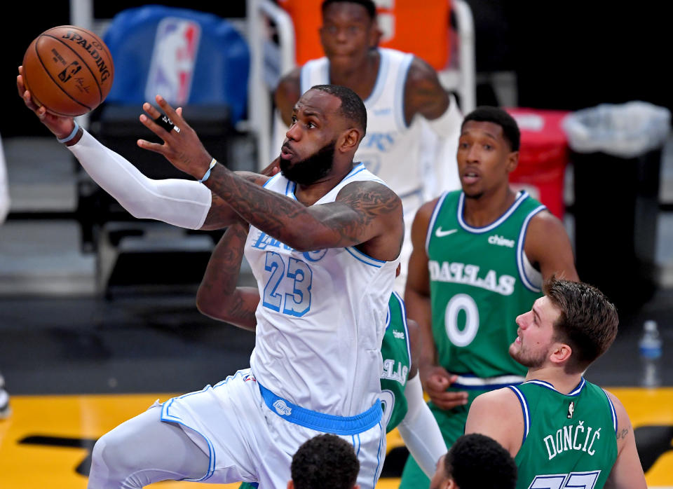 Dec 25, 2020; Los Angeles, California, USA;  Los Angeles Lakers forward LeBron James (23) drives past Dallas Mavericks forward Dorian Finney-Smith (10) and Dallas Mavericks guard Luka Doncic (77) for a basket in the first quarter of the game at Staples Center. Mandatory Credit: Jayne Kamin-Oncea-USA TODAY Sports