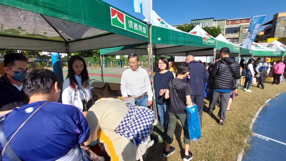 台北市議員陳政忠與北市社會局長姚淑文在現場協助發放物資給社子地區低收入戶居民。(記者張欽攝影)