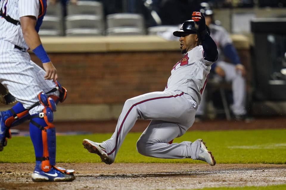 Atlanta Braves' Ozzie Albies, right, slides past New York Mets catcher James McCann to score during the sixth inning of a baseball game Monday, May 2, 2022, in New York. (AP Photo/Frank Franklin II)