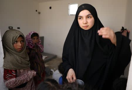 Girls look at Lebanese Nour al-Huda, wife of a former Islamic State fighter, at a camp for displaced people in Ain Issa, north of Raqqa, Syria June 21, 2017. Picture taken June 21, 2017. REUTERS/Rodi Said