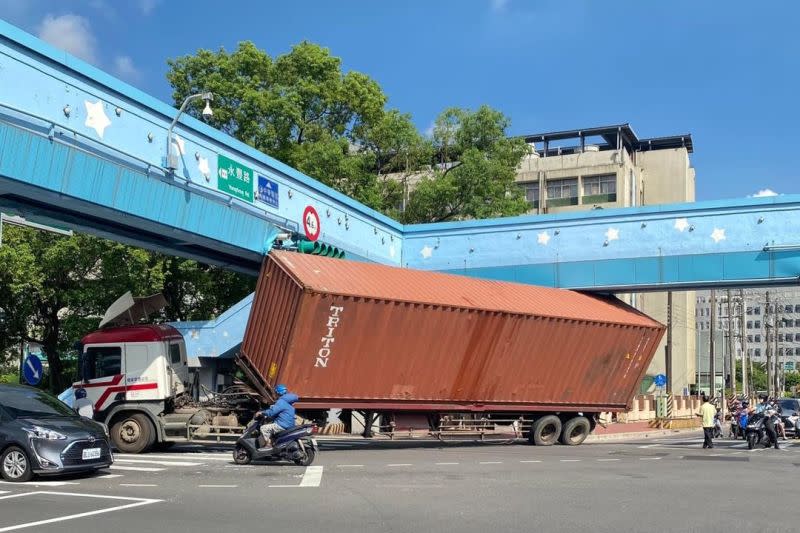 ▲桃園市永豐路，今（10）日早上9點多，一輛貨櫃車撞上天橋，車身傾斜卡在路中央，讓周遭交通大亂。（圖／翻攝自桃園都臉書）