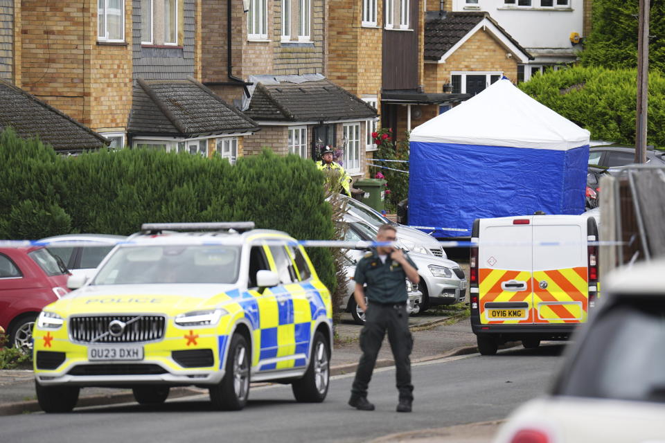 Police and emergency services at the scene in Ashlyn Close, after an incident on Tuesday evening, in Bushey, Hertfordshire, England, Wednesday, July 10, 2024. British police were hunting for a man believed to be armed with a crossbow on Wednesday after three women were killed in a house near London. The BBC said the women killed were the family of its main radio racing commentator John Hunt. (James Manning/PA via AP)