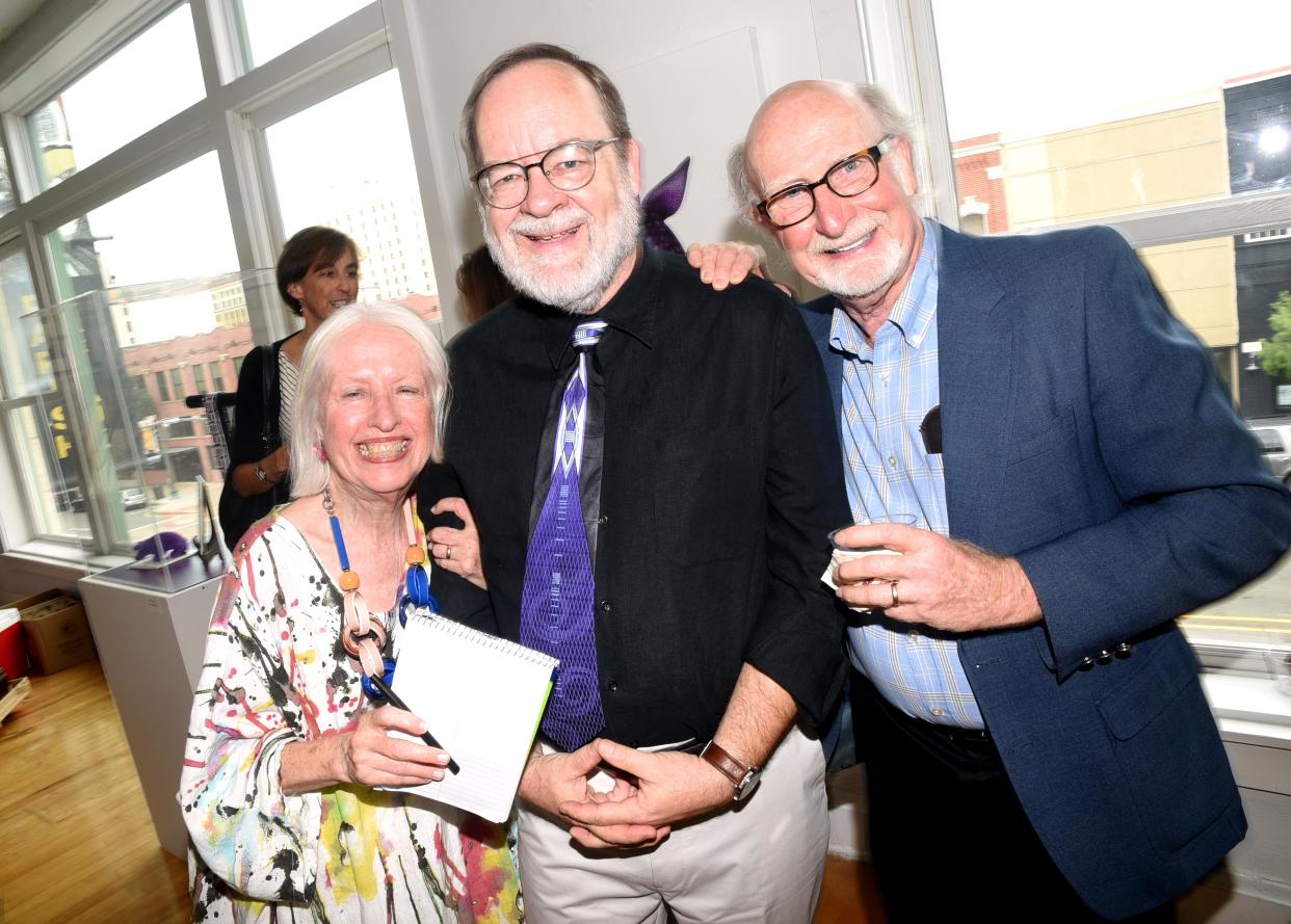 Neil Johnson in the center with Maggie Martin, left, and Paul L. Schuetze, right, during his photography exhibit at Artspace in 2019.