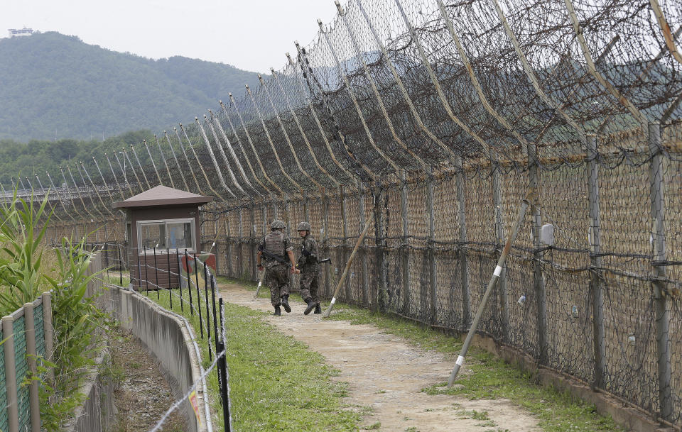 FILE - South Korean soldiers patrol while hikers visit the DMZ Peace Trail in the demilitarized zone in Goseong, South Korea, June 14, 2019. A series of low-slung buildings and somber soldiers dot the landscape of the DMZ, or demilitarized zone, the swath of land between North and South Korea where a soldier on a tour crossed into North Korea on Tuesday, July 18, 2023, under circumstances that remain unclear. (AP Photo/Ahn Young-joon, File)