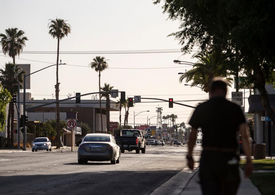 A man walks down the sidewalk along Main Street in Brawley, Calif., Wednesday, May 18, 2022.