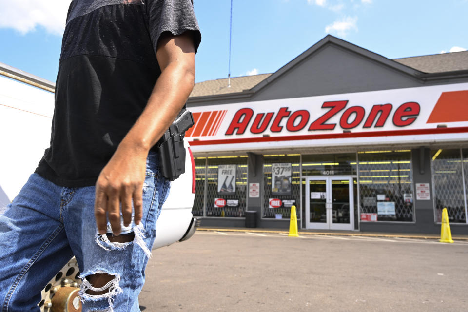 FILE - A man carrying a firearm on his hip for protection leaves an Auto Zone store, Thursday, Sept. 8, 2022, in Memphis, Tenn. On Thursday, Sept. 13, 2022, police revised the number of people killed in a man's shooting rampage from four to three after a different suspect was identified in the slaying of a teenager during the tense ordeal in Memphis. (AP Photo/John Amis, File)