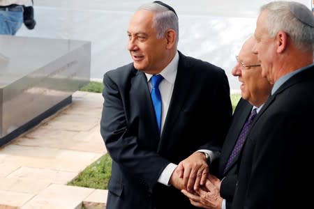 Israeli Prime Minister Benjamin Netanyahu, Israeli President Reuven Rivlin and Benny Gantz, leader of Blue and White party, hold hands at a memorial ceremony for late Israeli President Shimon Peres, at Mount Herzl in Jerusalem